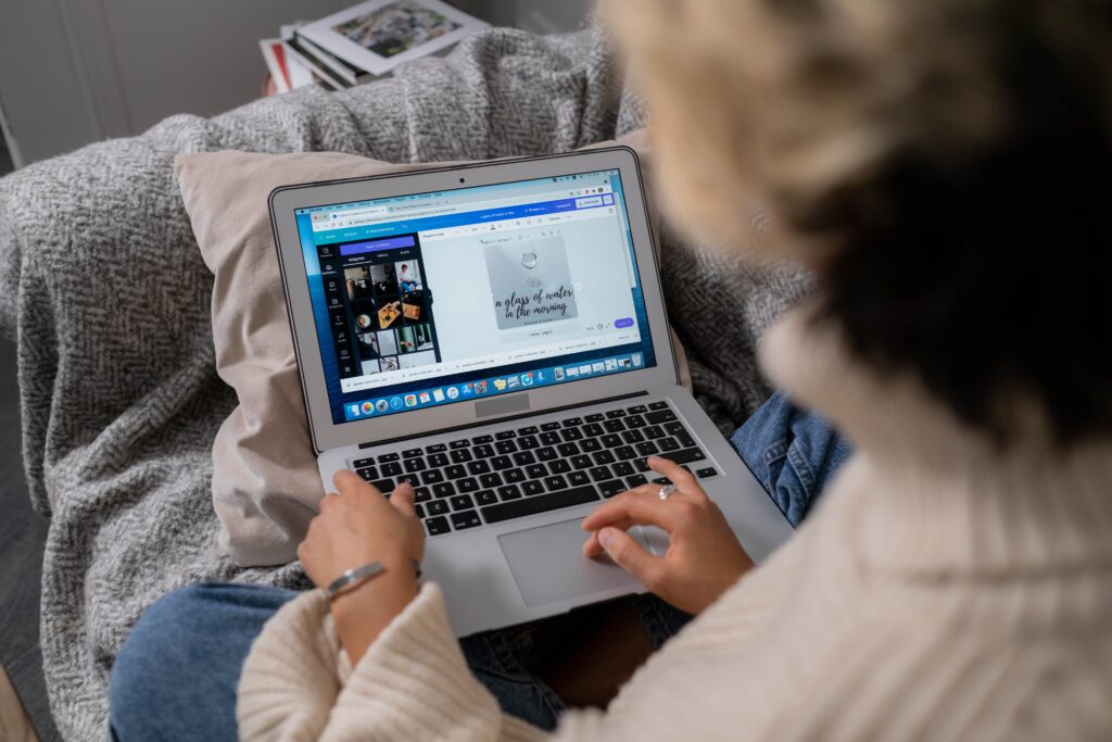 Woman on a laptop working in Canva to design a custom graphic